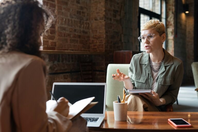 Two young businesswomen consulting at meeting